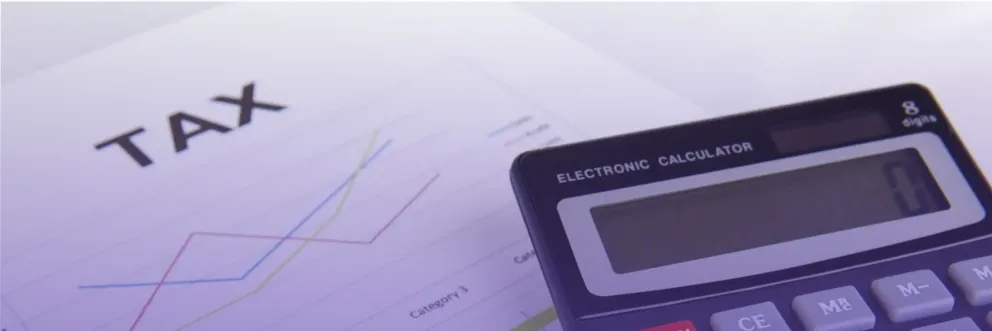 Close-up of a tax document with colorful line charts and a calculator, symbolizing financial analysis under soft purple lighting.