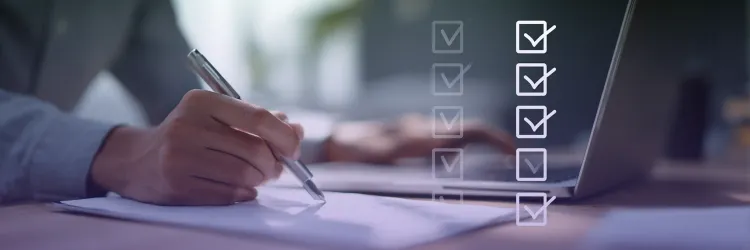 A person writing on paper next to a laptop with digital checklist icons overlayed, symbolizing workflow completion and task management
